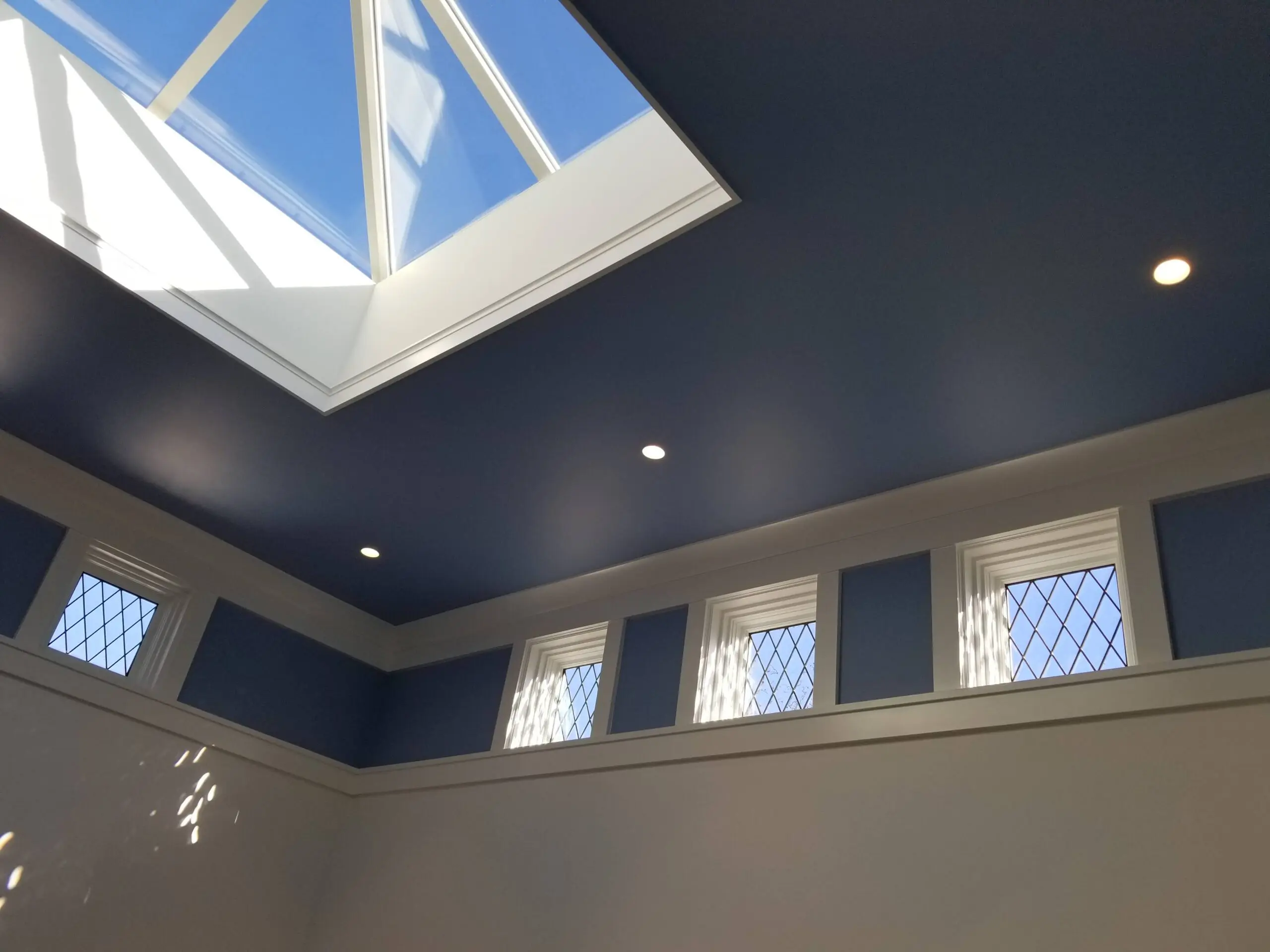 Interior ceiling with skylight and small windows, featuring a dark blue and white color scheme.