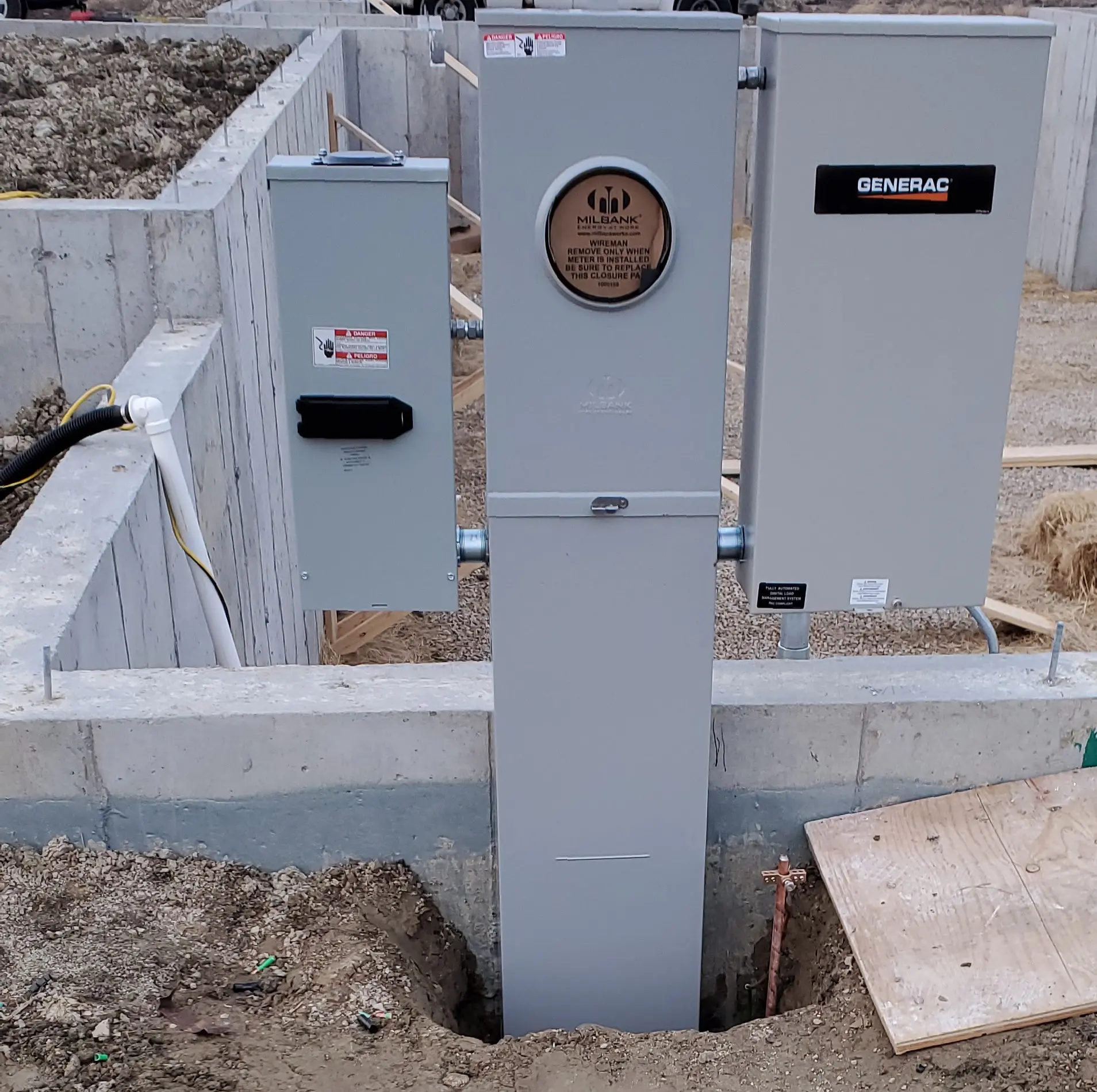 Electrical utility boxes installed on a concrete base outdoors.