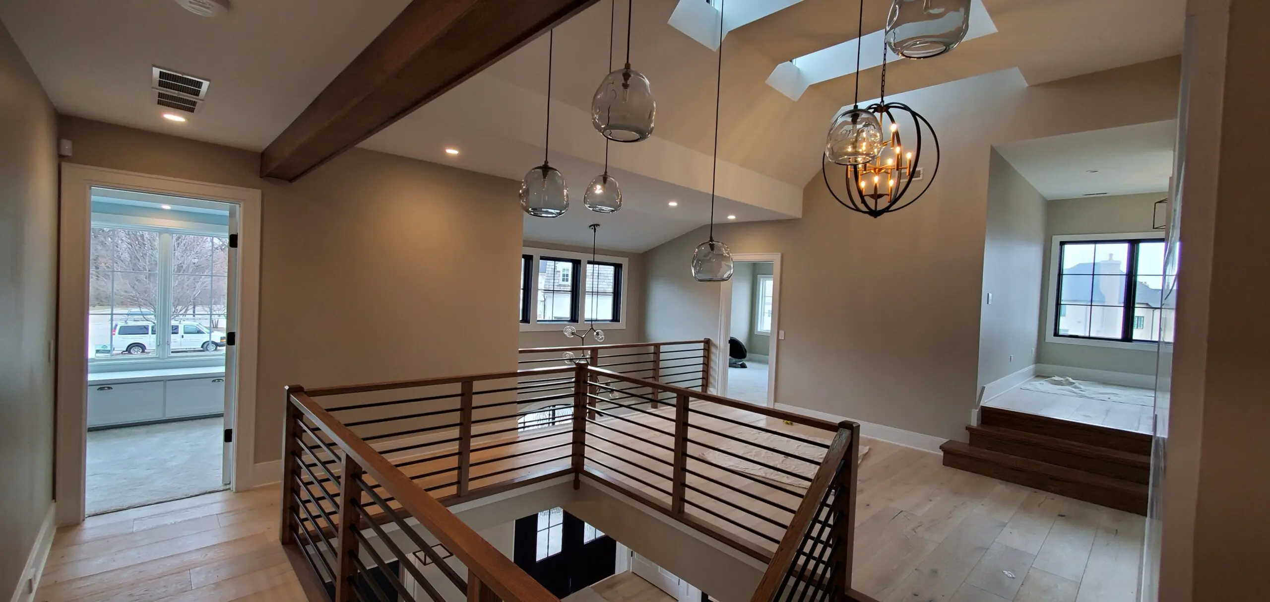 Modern loft interior with wooden railings and hanging light fixtures.