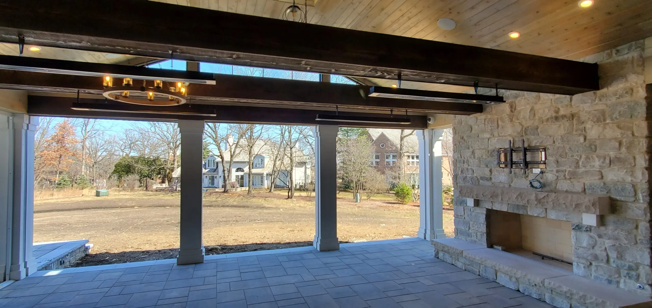 Covered patio with ceiling fan overlooks a grassy backyard and neighboring houses.