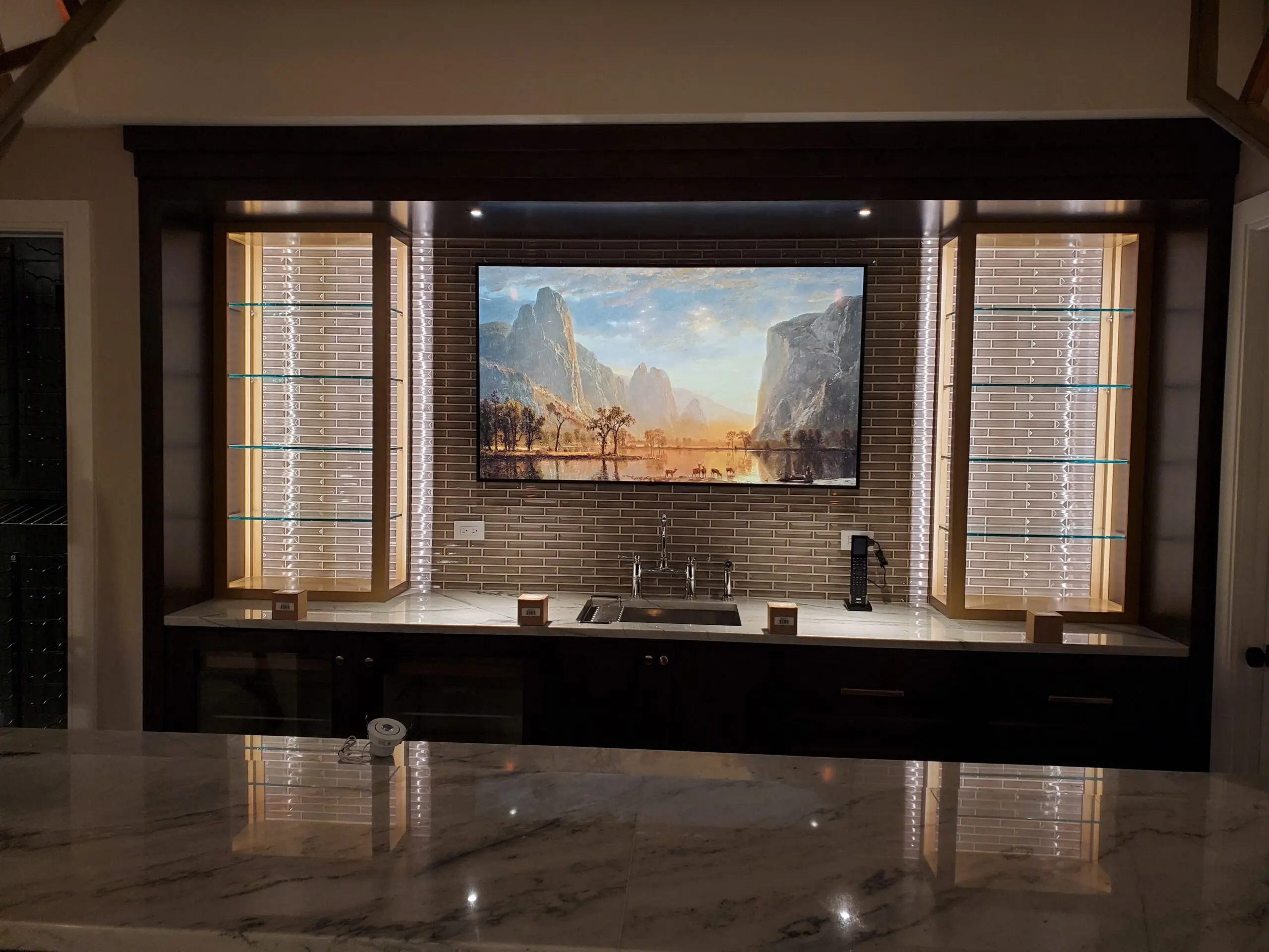 Modern kitchen with a large TV above the stove framed by windows.