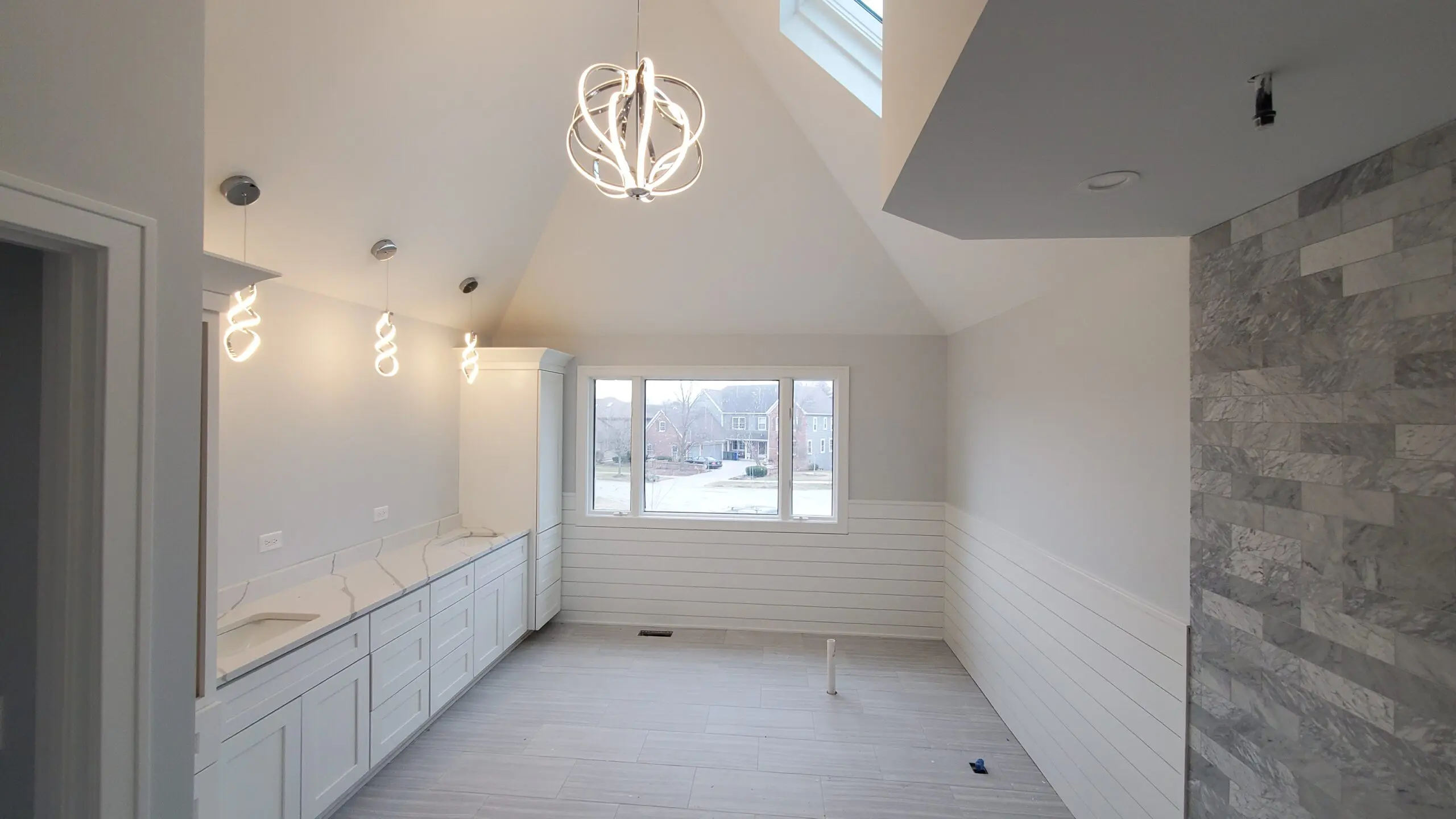 Bright, modern, empty room with large window and white tiled walls.
