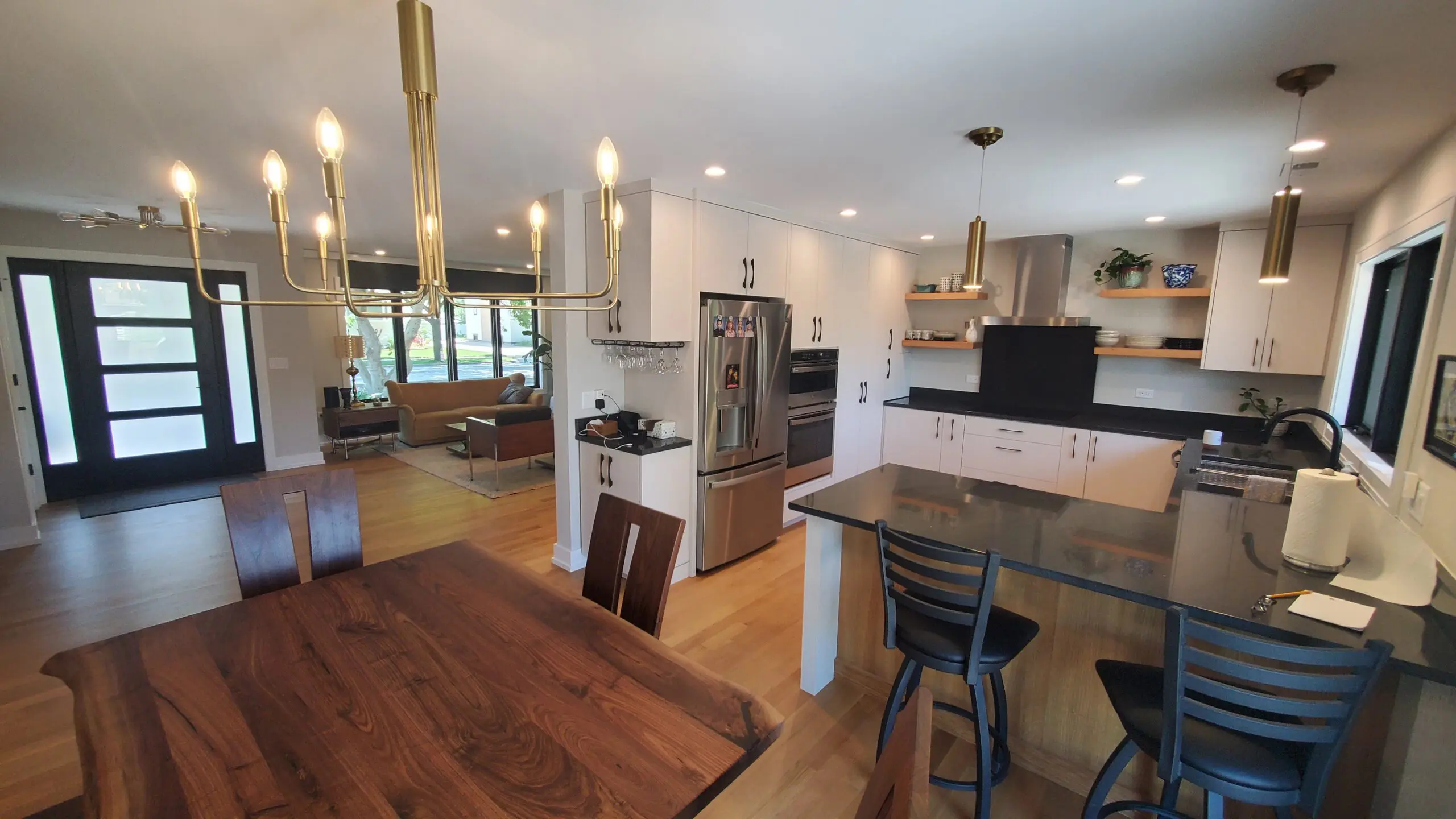 Spacious modern kitchen with wooden dining table and island seating.