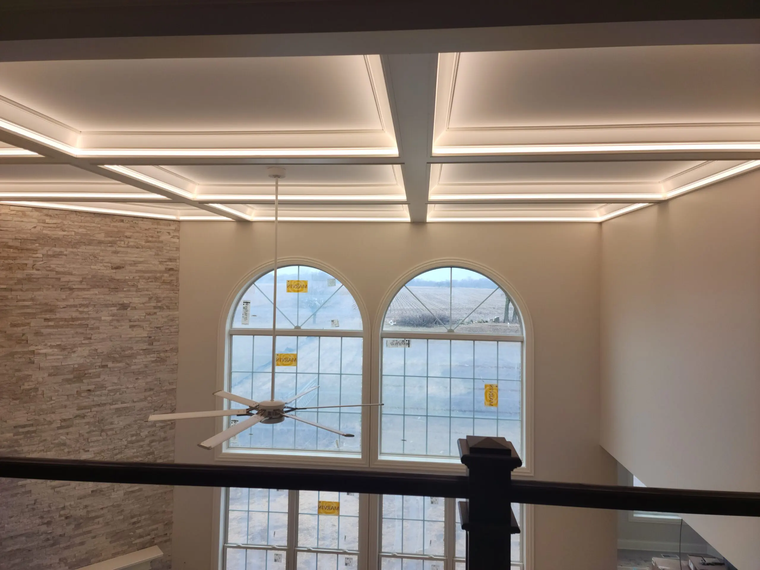 Elegant ceiling with recessed lighting above arched windows.