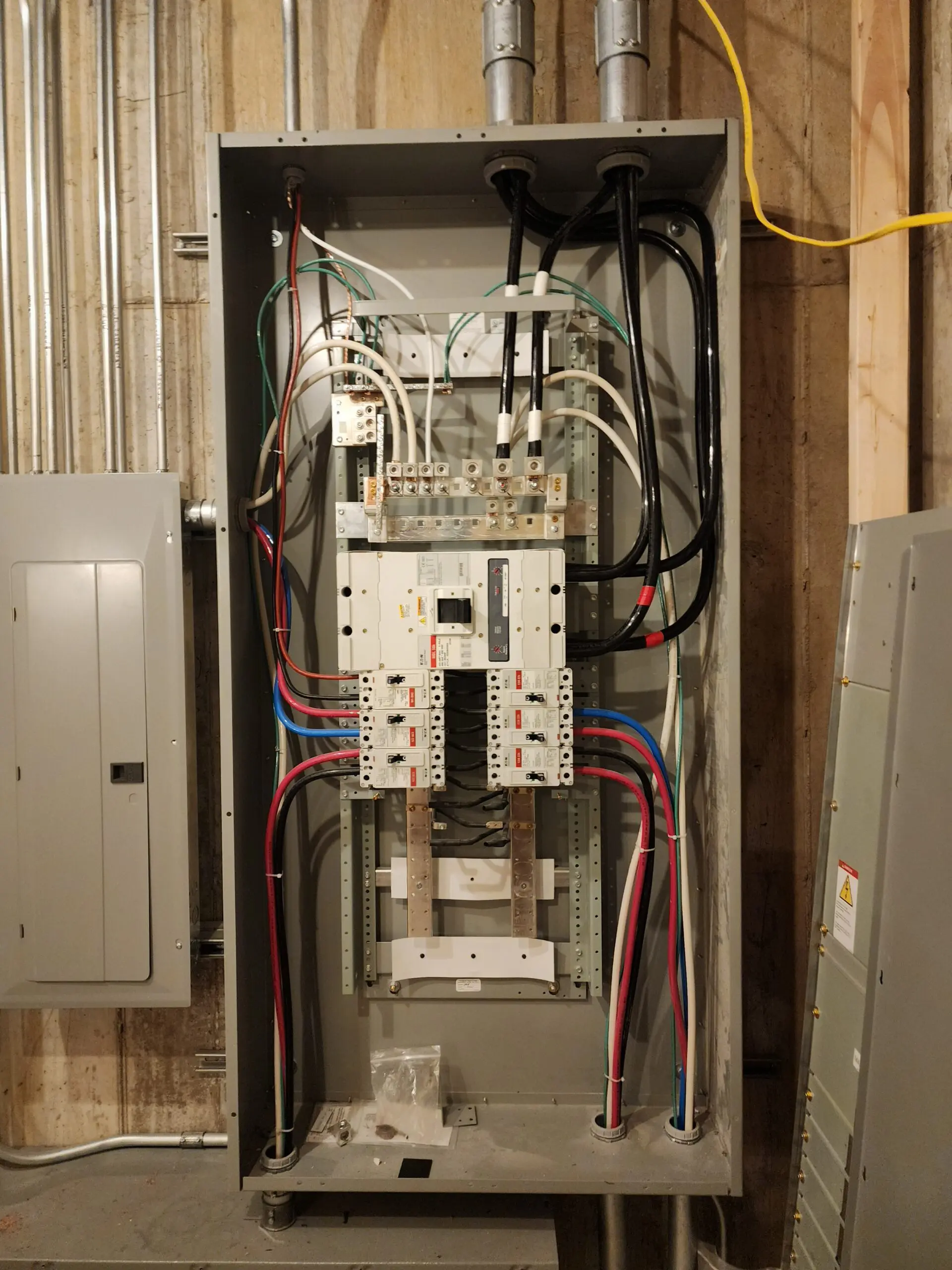 Open electrical panel with circuit breakers and wiring.