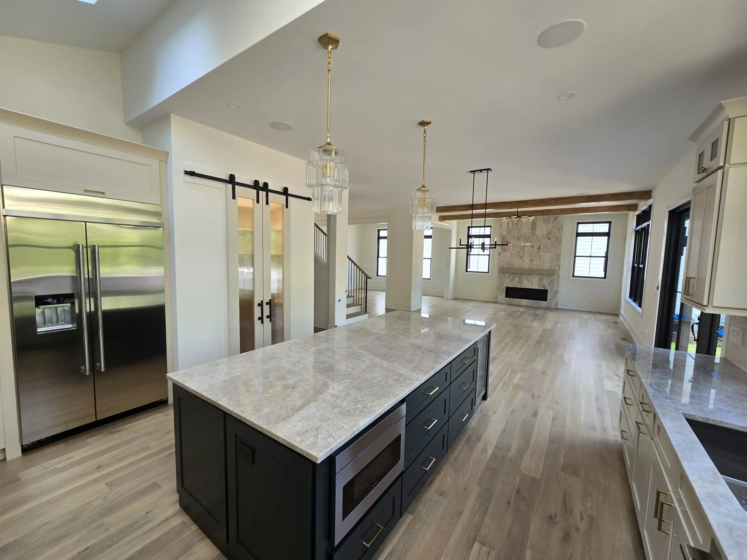 Modern kitchen with marble countertops and open living space.