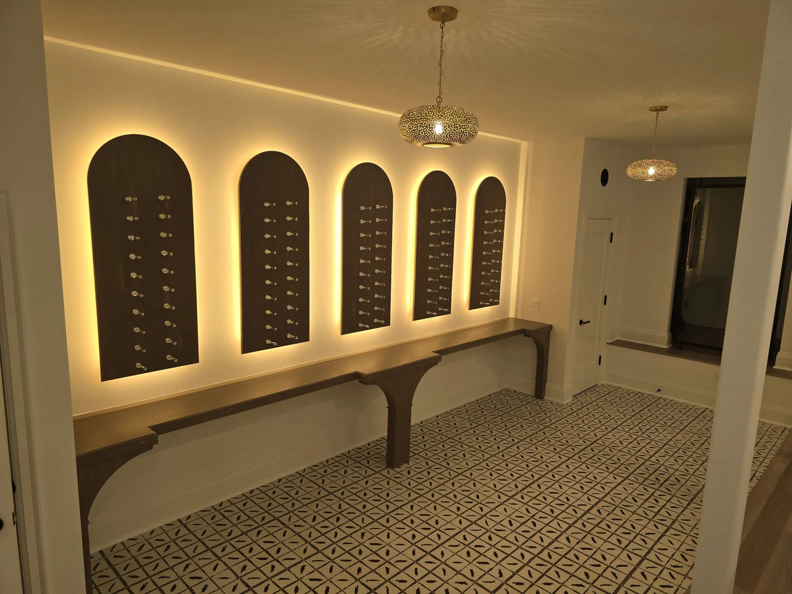 Elegant wine cellar with arched wall niches and ambient lighting.