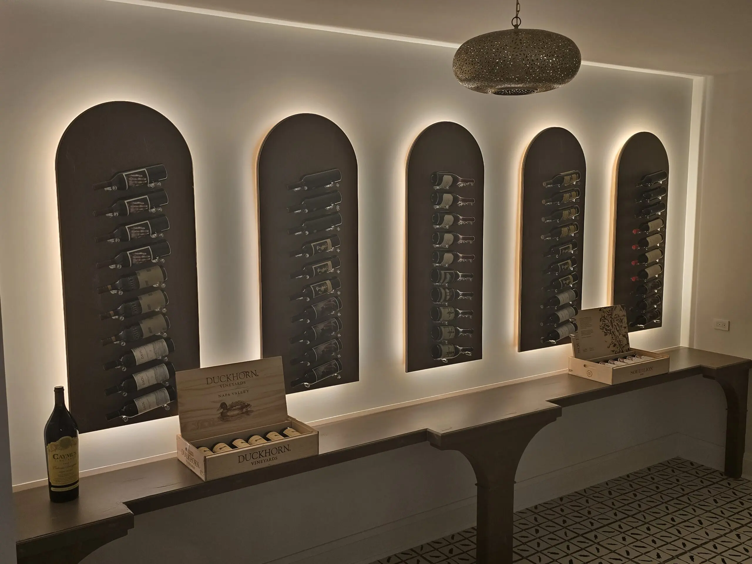 Elegant wine cellar with arched niches and ambient lighting.